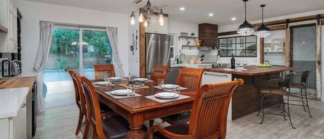 Un coin repas avec une table en bois dressée pour six personnes, entourée de chaises.