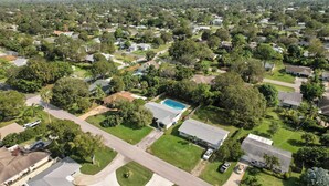 Zona residencial con casas, una piscina y un edificio grande con techo plano.
