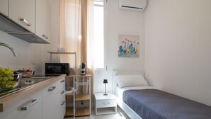 A compact bedroom with a single bed, a bedside table, and a nightstand. - GuestHost - Casa Perni - The Green Room (Palermo)