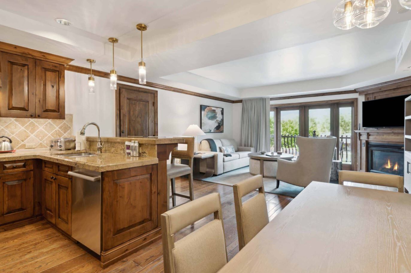 Une cuisine moderne avec des meubles en bois, un îlot central et des luminaires suspendus.