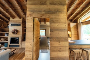 A wooden interior with a central hallway leading to a kitchen area.