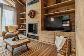 A cozy living room with a fireplace, a television, and a comfortable seating area.