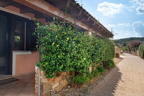 Un edificio con pared de piedra y barandilla de metal.