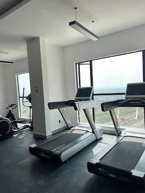 A gym with treadmills, a stationary bike, and a rowing machine. - Traveler's Loft- Park views near JKIA&SGR with Pool & Gym (Nairobi)