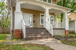 A two-story house with a front porch, a brick foundation, and a number '3411' on the door.