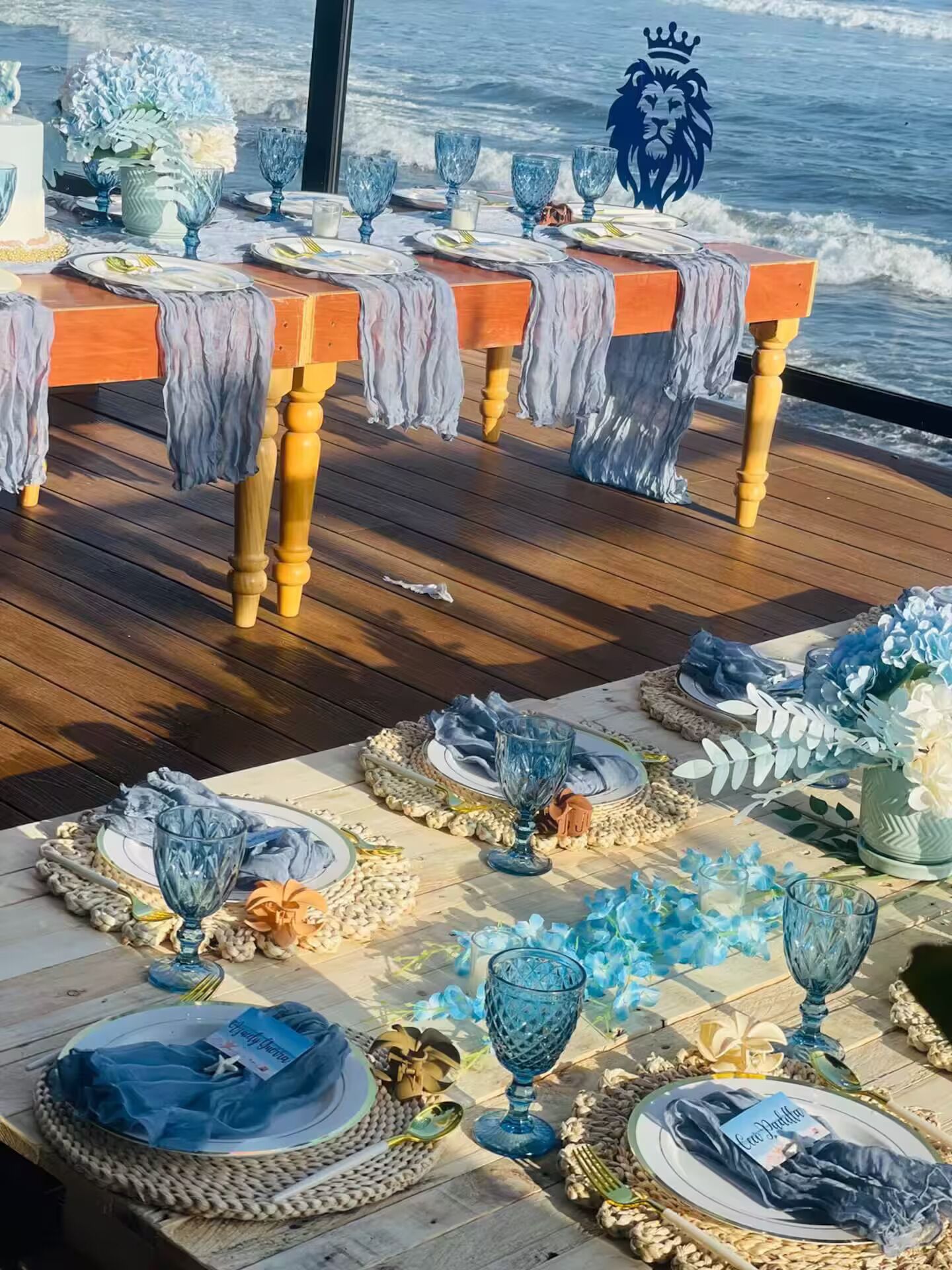 Ett dukat bord för en måltid med utsikt över havet, med vackra glas och tallrikar.