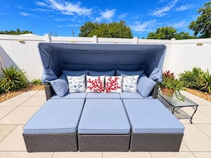 A sectional sofa with a canopy, multiple cushions, and a small table with plants. - Clearwater Oasis | Private Pool | 5mi from Beach (Pinellas County)