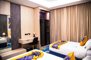 A hotel room with two beds, a desk, a chair, a wardrobe, and a large window with curtains.