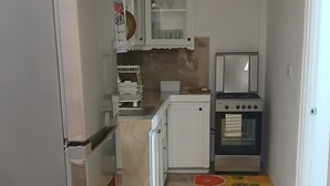 Una cocina con refrigerador, horno y armarios.