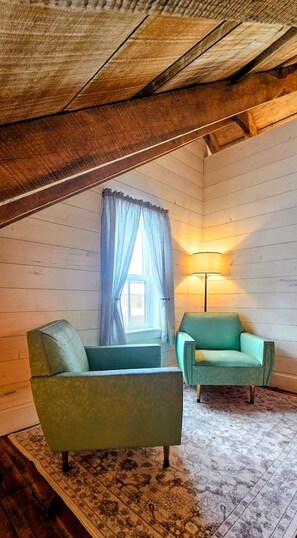 A room with two armchairs, a lamp, and a window with curtains.