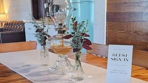 Une table en bois avec un set de table, un panneau indiquant « livre d’or pour les invités » et un stylo.