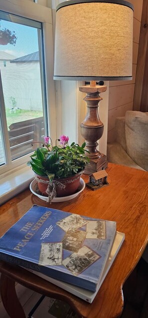 A wooden table with a lamp, a book, and two potted plants.