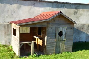 A wooden structure with a sloped roof and a circular entrance.