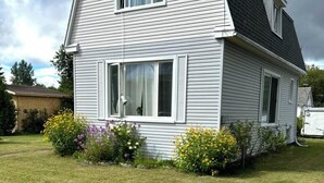 Ein zweistöckiges Haus mit geneigtem Dach und weißer Fassade.