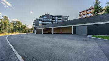 A modern building with multiple parking spaces and a covered driveway.