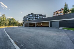 A modern building with multiple parking spaces and a covered driveway.