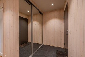 A room with wooden panel walls, a sliding glass door, and a tiled floor.