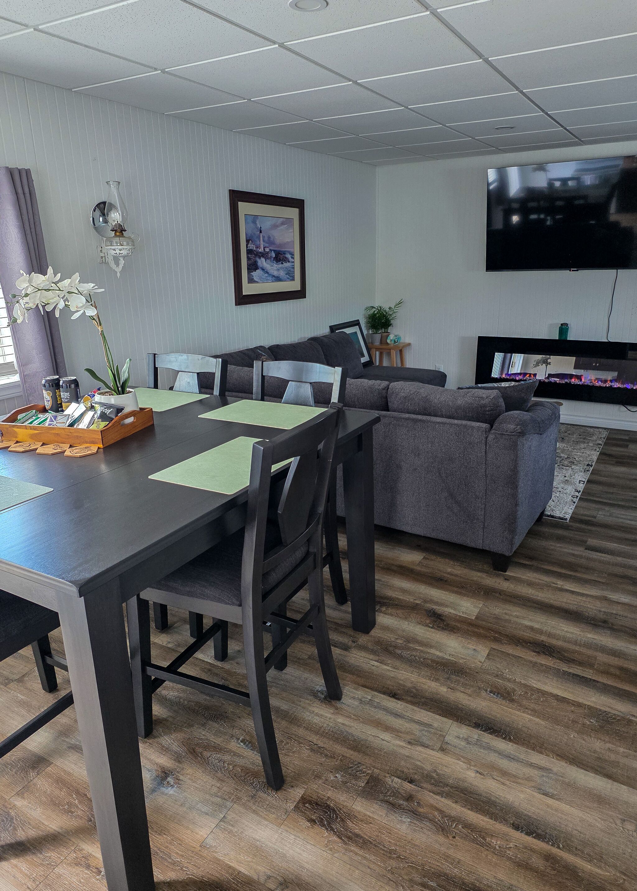 Una sala de estar moderna con una mesa de comedor, sofás y un televisor de pantalla plana.