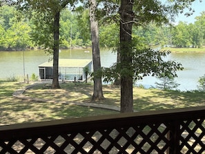 A lakeside cabin with a dock, surrounded by trees and a clear view of the water.