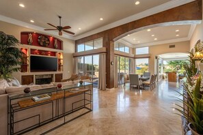 A spacious living area with a flat-screen TV, comfortable seating, and a glass coffee table. - Fairway Peaks at PGA West | Mountain & Golf Views (La Quinta)