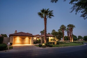 A residential house with a garage, surrounded by palm trees and a well-maintained lawn. - Fairway Peaks at PGA West | Mountain & Golf Views (La Quinta)