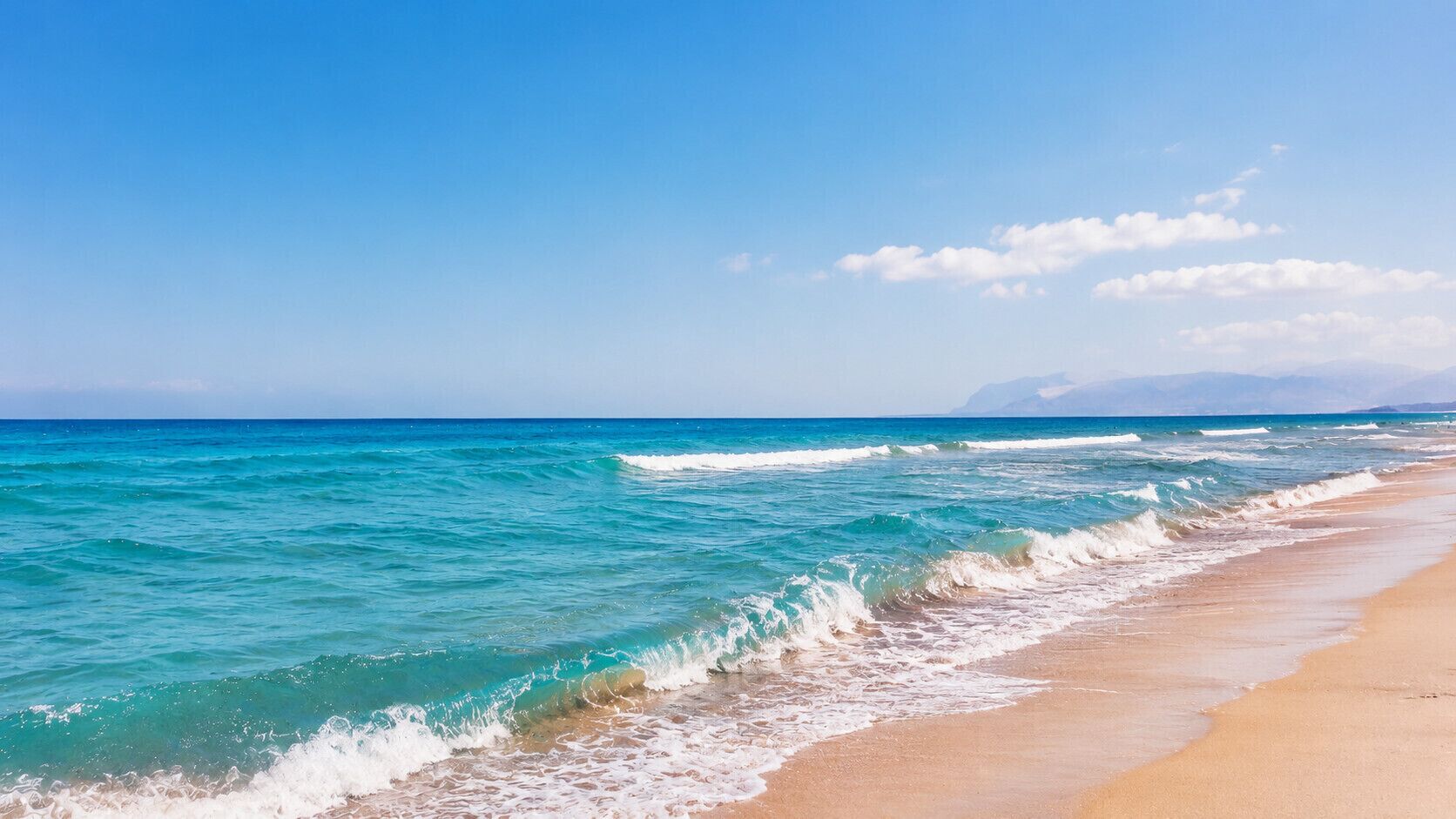 A beach with clear turquoise waters and a sandy shore.