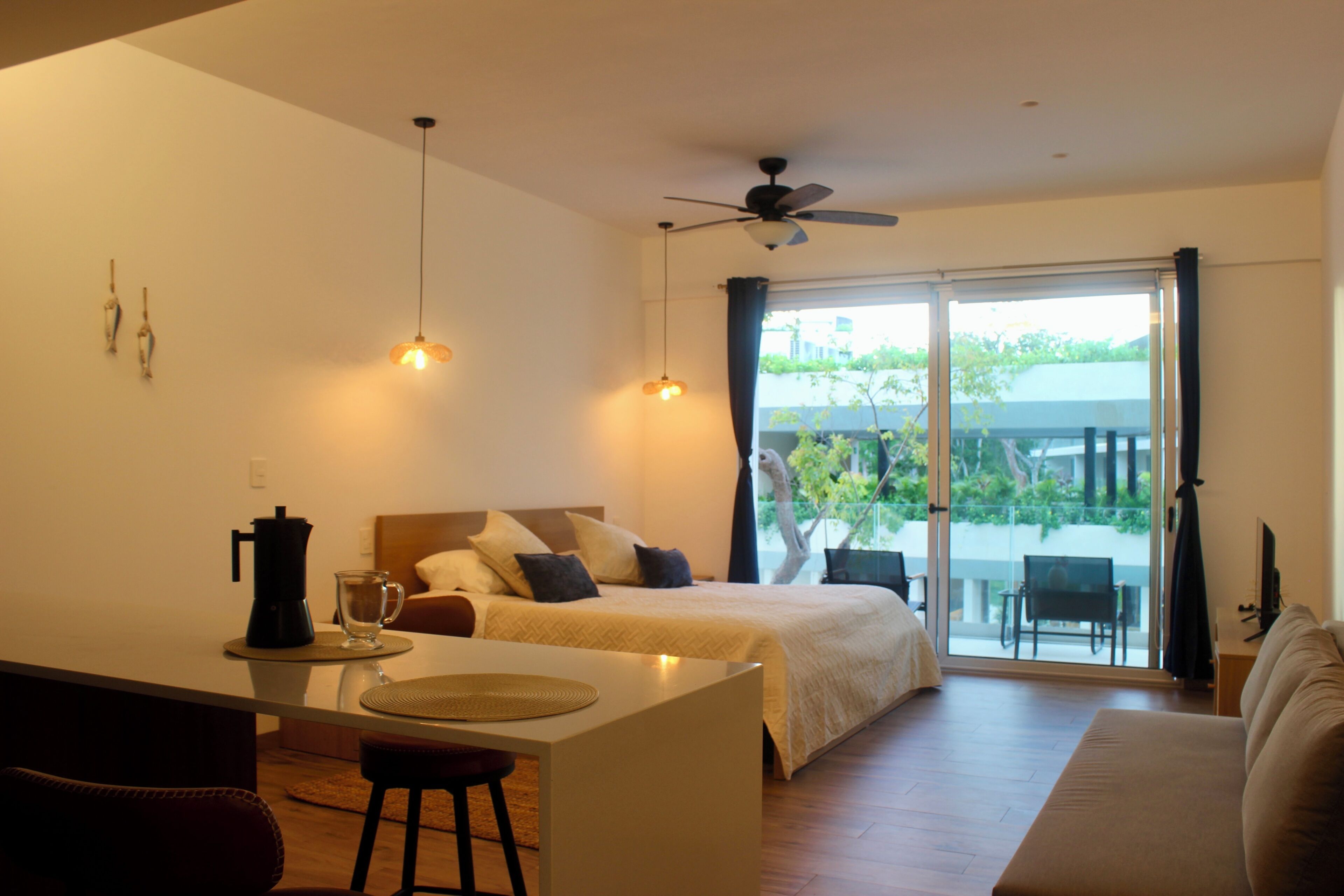 Ein modernes Hotelzimmer mit Bett, Essbereich und Balkon.
