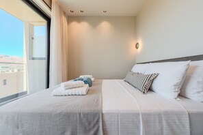 Ein Hotelzimmer mit Bett, Kissen, einem Nachttisch und einem Fenster mit Vorhängen.