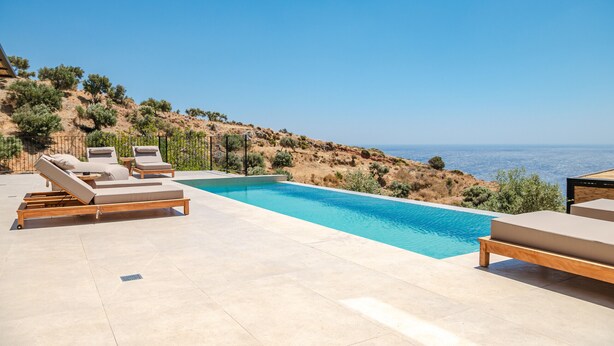 A pool area with lounge chairs and a view of the sea. - Metatulia Villa 6 – Private Pool, Jacuzzi & Views (Plakias)