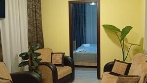 Un salon comprenant un canapé, une table basse et une plante en pot.