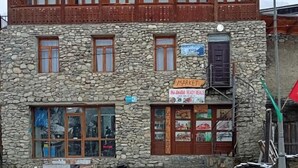 Un bâtiment à deux étages, doté d’une façade en pierre et d’étages supérieurs en bois, qui abrite un restaurant et dont l’enseigne indique la présence d’un marché.