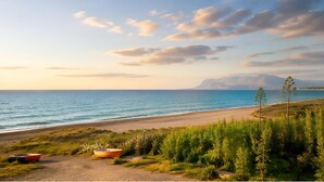 A coastal landscape with a beach, a boat, and vegetation. - La Finestra sul Mare (Alcamo)