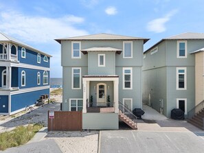 Un immeuble résidentiel de deux étages, doté d’un porche à l’avant, d’un escalier et d’un espace extérieur abrité.