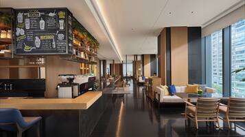 A modern cafe with a chalkboard menu, seating area, and large windows.