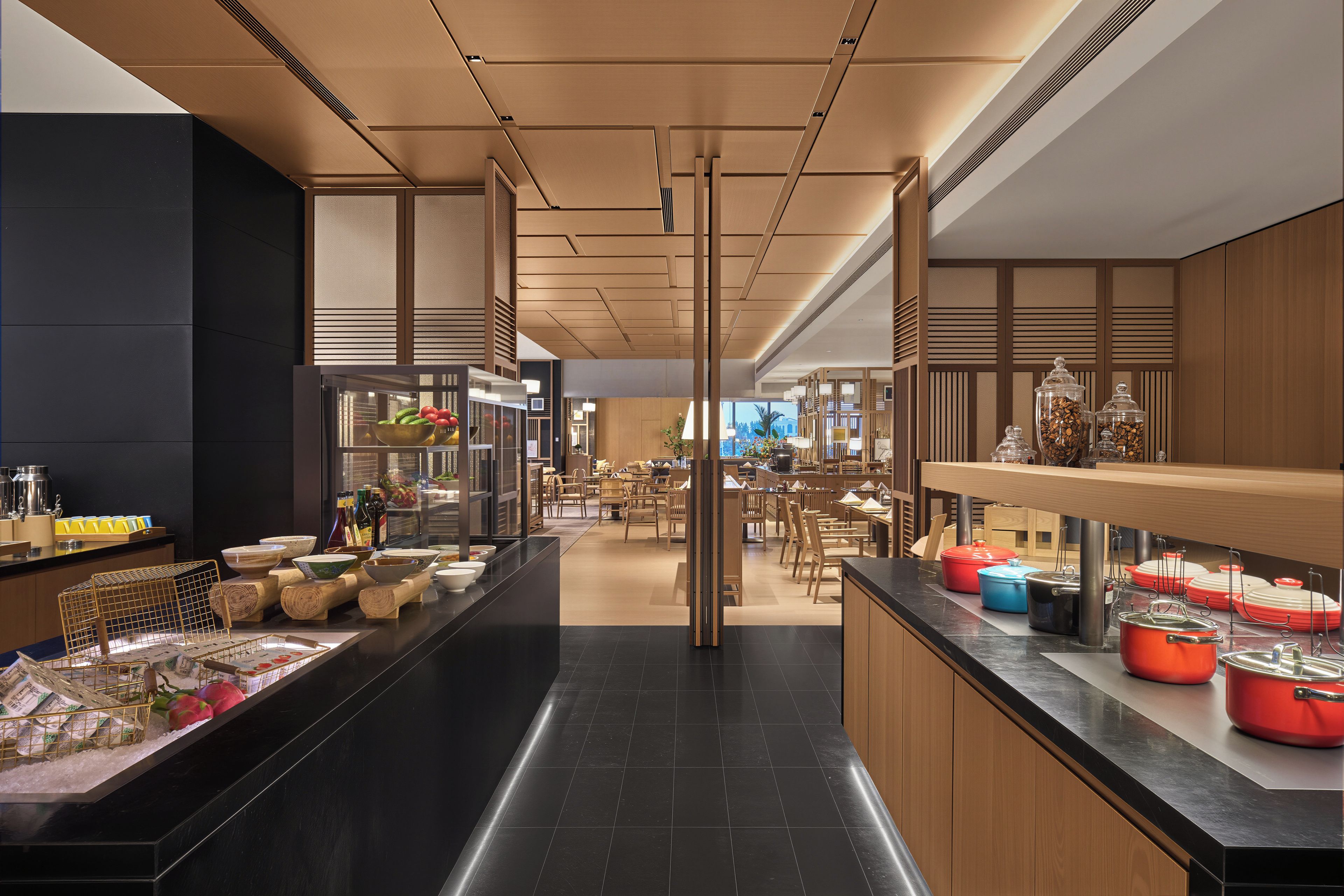 A modern hotel lobby with a central walkway, seating areas, and a reception desk.