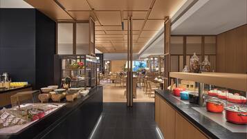 A modern hotel lobby with a central walkway, seating areas, and a reception desk.