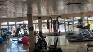 Un gimnasio con equipos de ejercicio variados, incluyendo cintas de correr, bicicletas estáticas y máquinas de pesas.