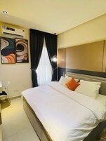 Una habitación de hotel con una cama, un escritorio y una silla.