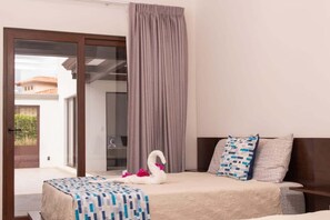 A hotel room with a bed, a curtain, and a view through a glass door. - Beautiful house with private pool Hacienda Pinilla (Hacienda Pinilla)