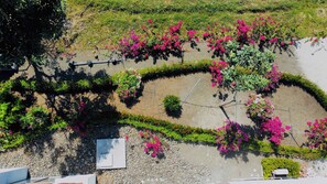 An aerial view of a landscaped garden with a circular flower bed, a paved walkway, and a stone wall. - Beautiful house with private pool Hacienda Pinilla (Hacienda Pinilla)
