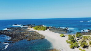 A coastal landscape with rocky terrain, clear blue waters, and sparse vegetation. - Beautiful house with private pool Hacienda Pinilla (Hacienda Pinilla)