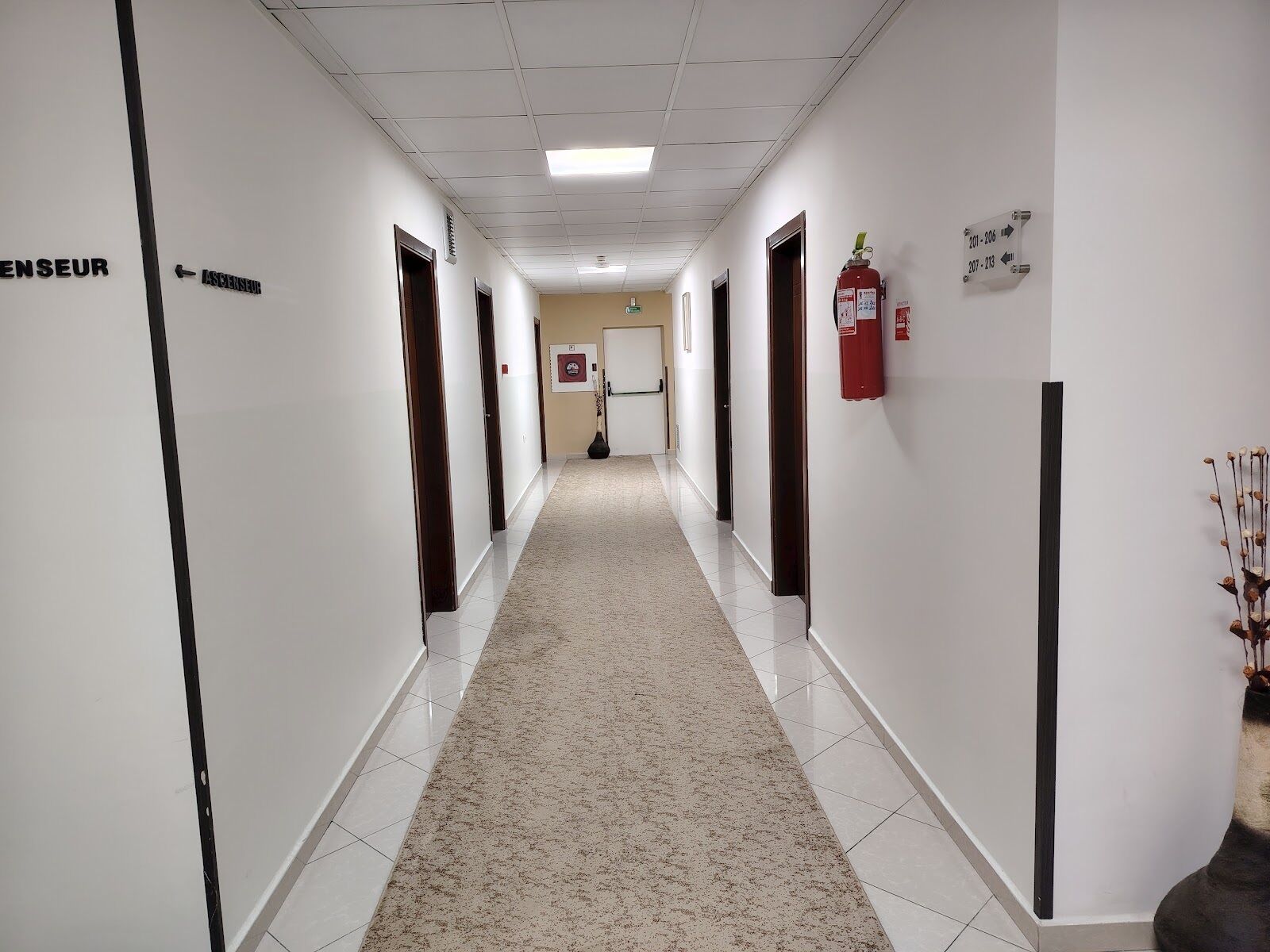 A corridor with doors labeled 'ENSEUR' and 'ASSEINSUF' leading to rooms.