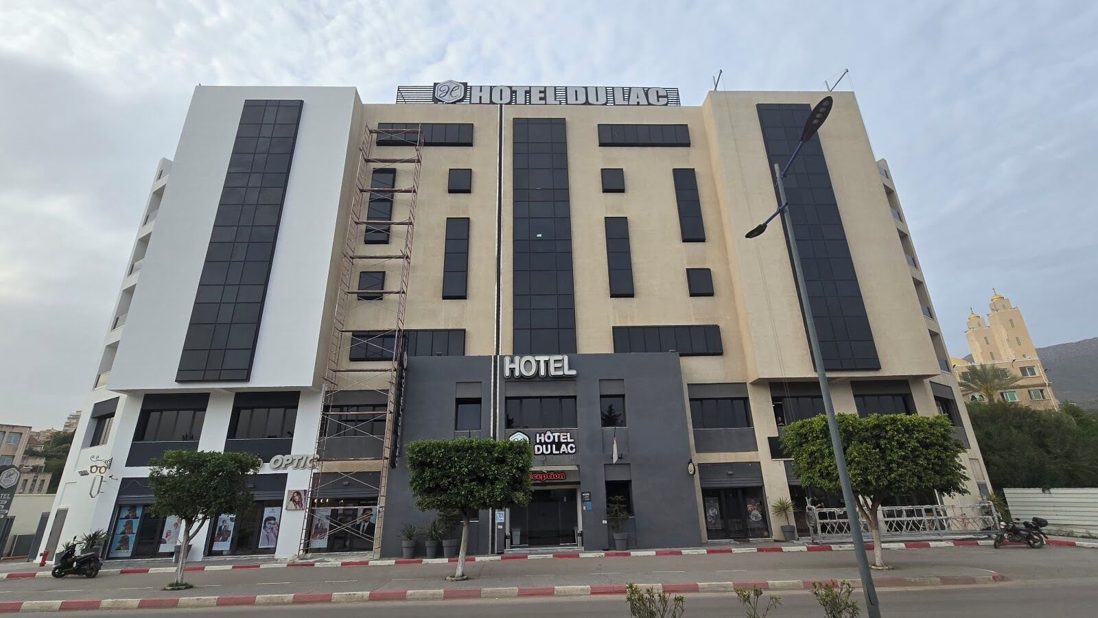 A multi-story hotel building with a prominent sign reading 'HOTEL DU LAC'.