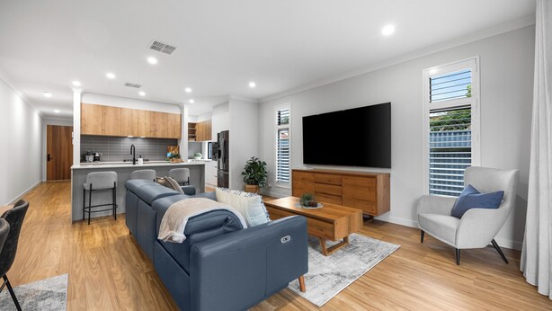 A modern living room with a sofa, a coffee table, and a TV. - The Torrens A Contemporary Escape in the Foothills (Kingswood)
