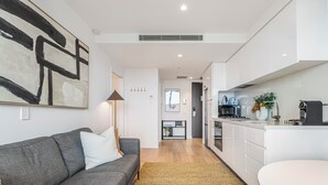 A modern kitchen with white cabinetry, a built-in oven, and a coffee machine. - Marco Panoramic Skyline Escape with Pool and Gym (Southbank)