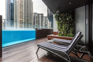 A rooftop terrace with a pool, lounge chairs, and a vertical garden. - Marco Panoramic Skyline Escape with Pool and Gym (Southbank)