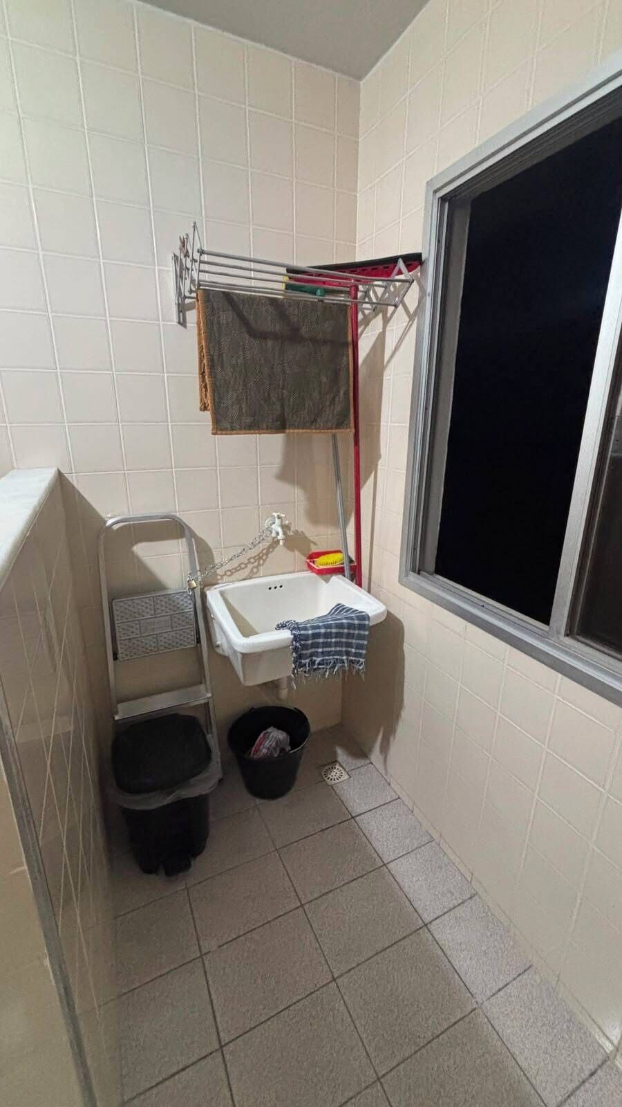 Un banyet petit amb finestra, un rentapeus, una barra de tovalloles i un safata de brossa.