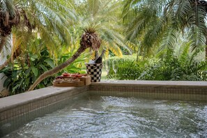 A pool area with a checkered bucket, two empty glasses, and a bottle of champagne.