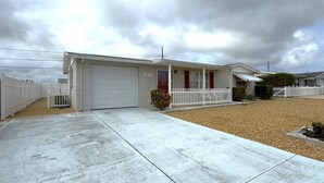 A single-story house with a garage, a front porch, and a driveway. - Relaxing Gulf Coast Retreat in Holiday, FL – Near Beaches, Dining & Florida Adventures (Holiday)