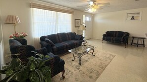 A living room with a sofa, a coffee table, and a small table. - Relaxing Gulf Coast Retreat in Holiday, FL – Near Beaches, Dining & Florida Adventures (Holiday)